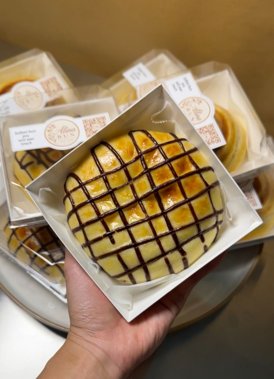 A chocolate bun in its box, held up close
