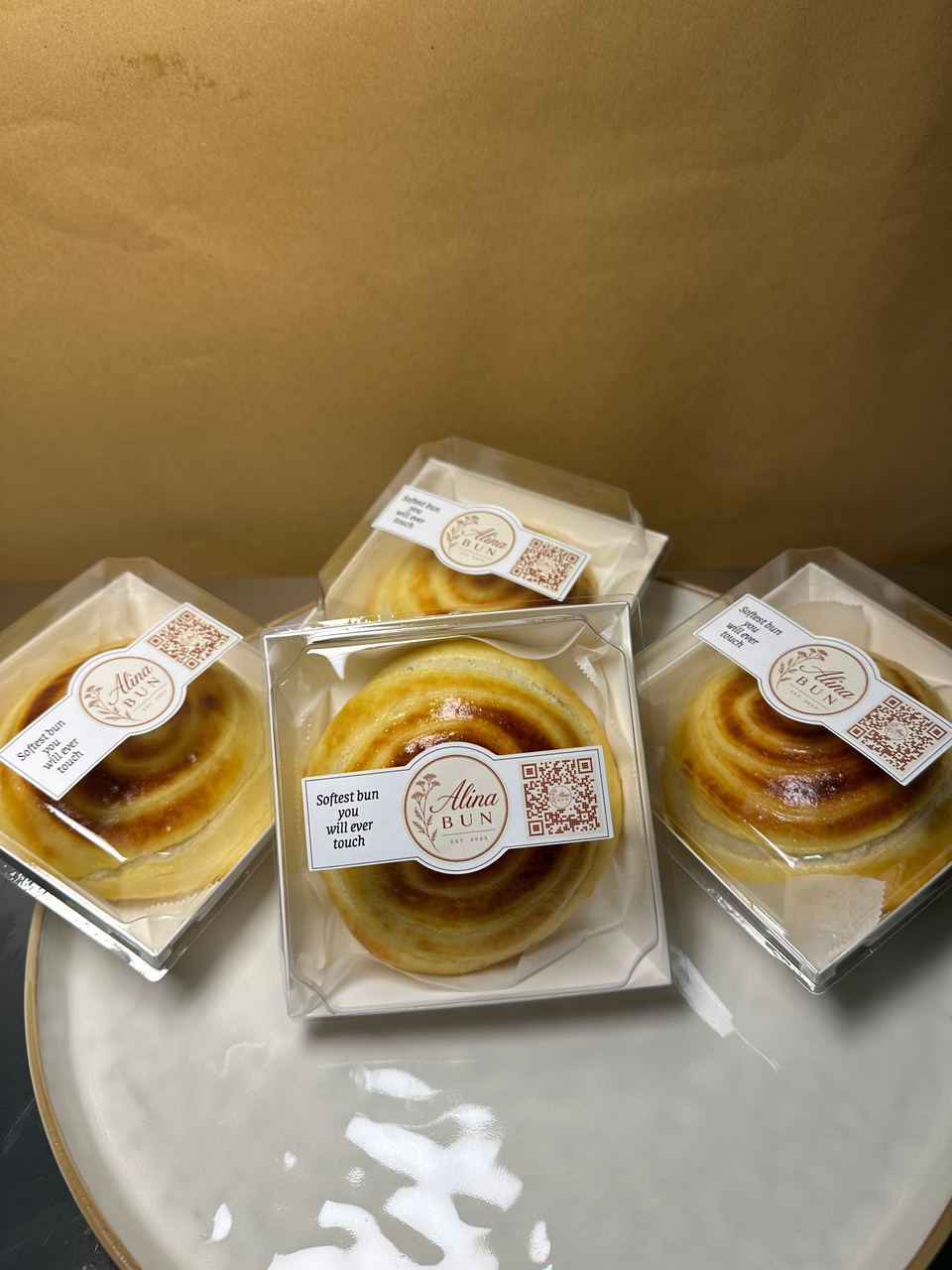 Boxed buns stacked on a plate, each with the Alina Bun label