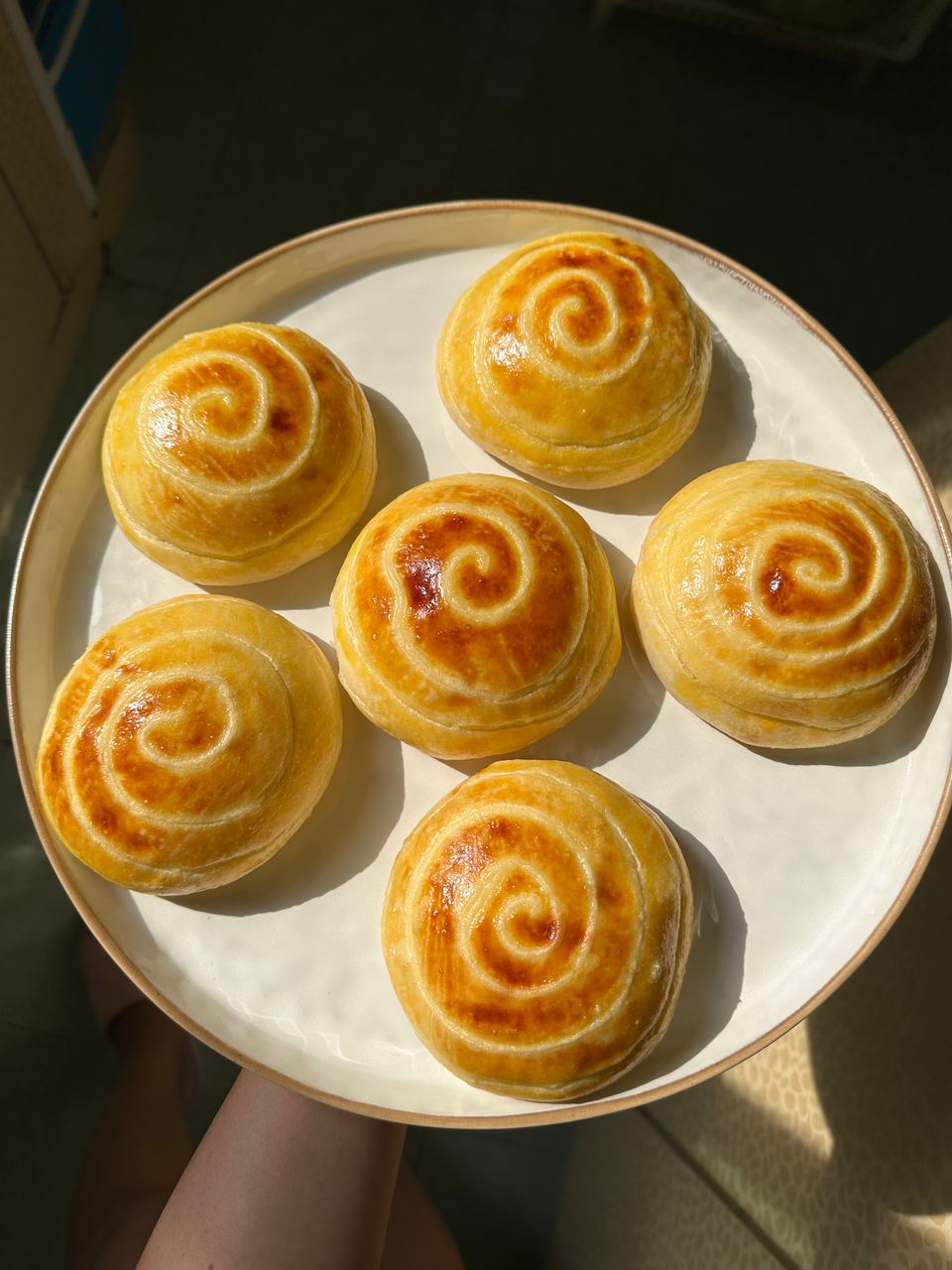 Cream buns with golden swirls on a plate