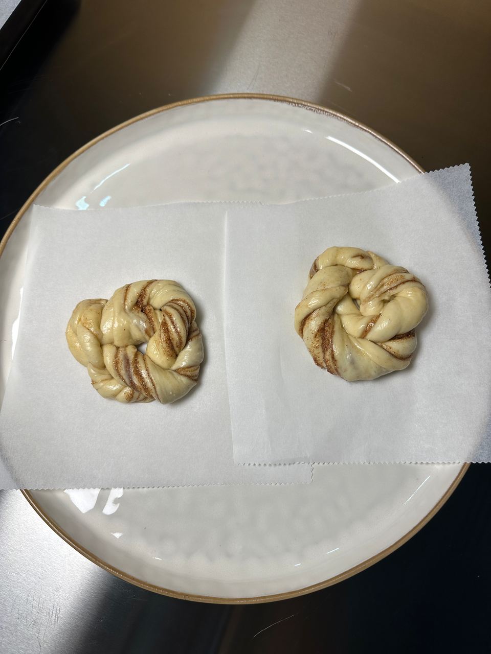 Two twisted knots of dough on baking paper