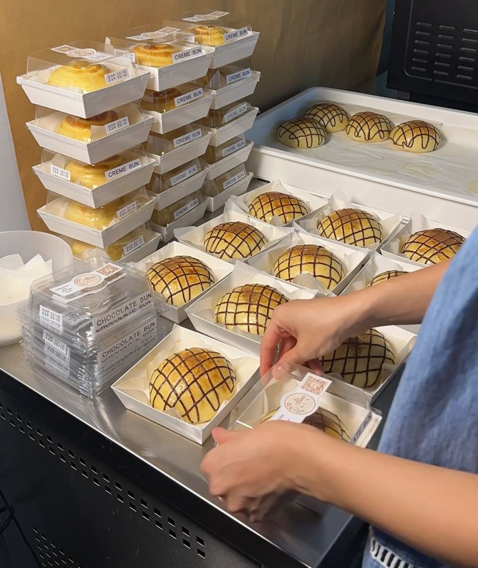 Hands packing buns into their boxes