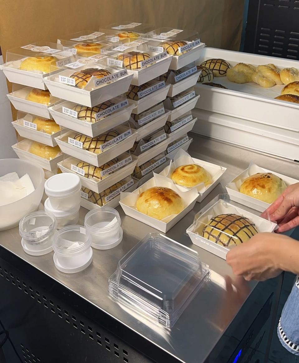 Buns being packed into boxes, with stacks of boxes behind